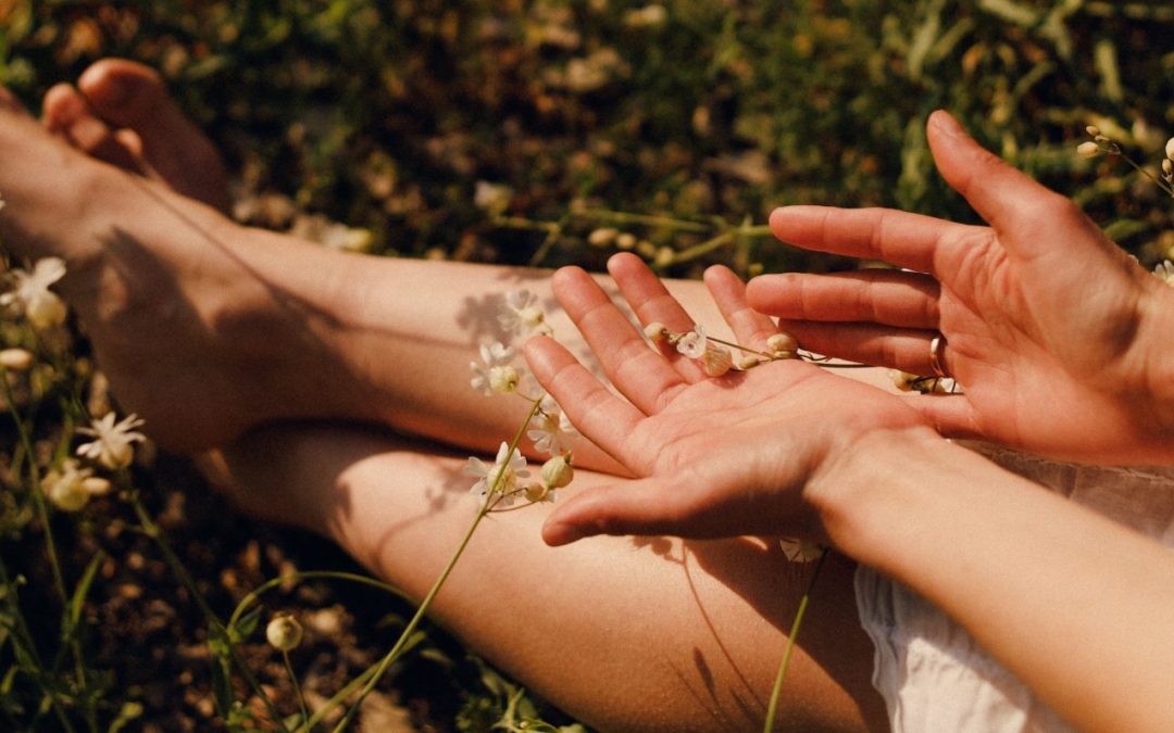 Close-up of female hands and feet with natural beauty treatments, surrounded by tender plants for a soothing aesthetic